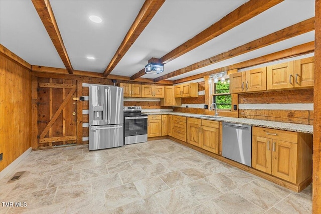 2318 Westwood St, Johnson City, TN 37604 - kitchen with stainless steel appliances, light stone finish floors, a sink, beamed ceiling, and wood walls