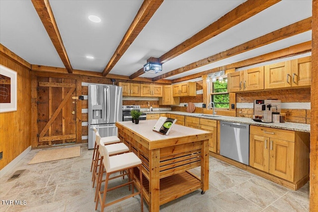 2318 Westwood St, Johnson City, TN 37604 - kitchen featuring appliances with stainless steel finishes, a sink, beam ceiling, light stone finish floors, and wooden walls