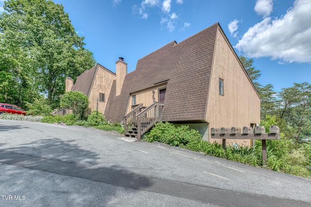 view of side of home with a shingled roof
