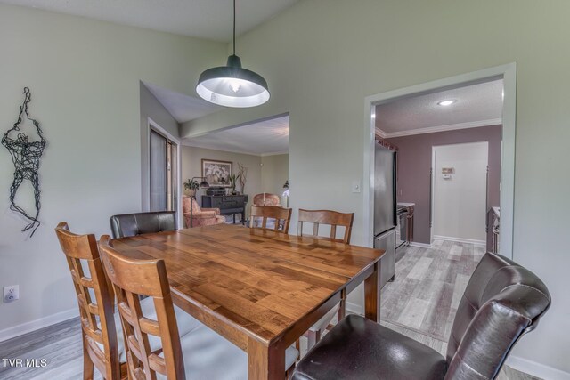 dining room with light wood finished floors, baseboards, ornamental molding, and recessed lighting