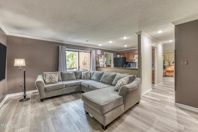 living room with a textured ceiling, crown molding, light wood-style flooring, baseboards, and recessed lighting