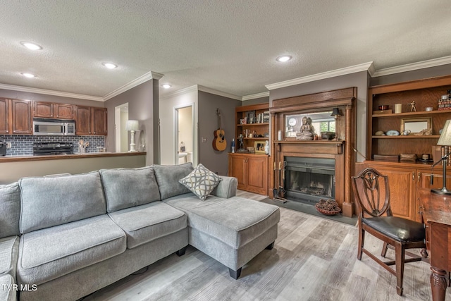 living room with light wood finished floors, ornamental molding, a textured ceiling, a fireplace with flush hearth, and recessed lighting