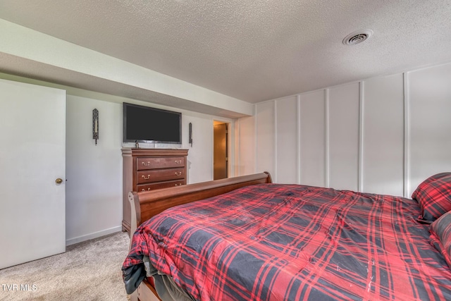 carpeted bedroom featuring a textured ceiling and baseboards