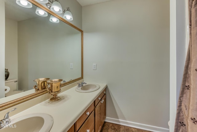 bathroom with toilet and double vanity