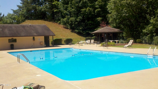 community pool featuring a gazebo, a patio area, and fence