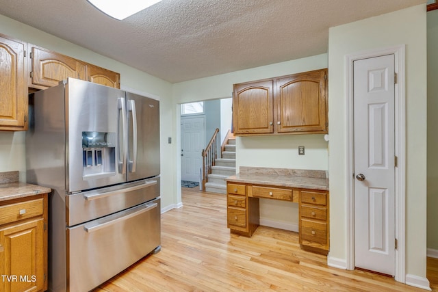 212 Old Castle Rd, Kingsport, TN 37660 - kitchen with stainless steel fridge with ice dispenser, light wood-style flooring, a textured ceiling, baseboards, and brown cabinetry