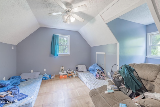 240 Old Railroad Grade Rd, Roan Mountain, TN 37687 - bedroom with a textured ceiling, multiple windows, wood finished floors, vaulted ceiling, and ceiling fan