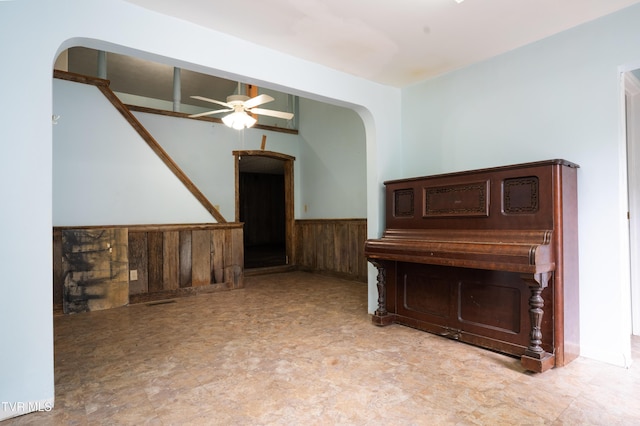 380 Oak Grove Rd, Johnson City, TN 37615 - unfurnished living room featuring wainscoting, arched walkways, ceiling fan, and wood walls