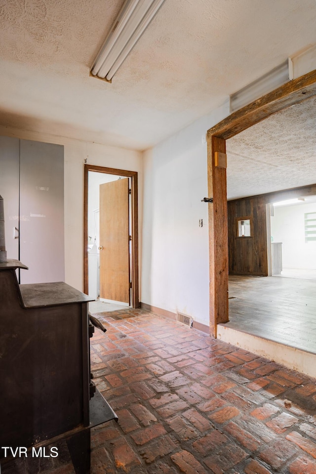 380 Oak Grove Rd, Johnson City, TN 37615 - foyer entrance featuring a textured ceiling, a wood stove, brick flooring, washer / clothes dryer, and baseboards