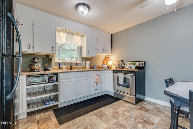 505 Chapman St, Johnson City, TN 37604 - kitchen featuring stainless steel range with electric cooktop, freestanding refrigerator, a sink, and white cabinets