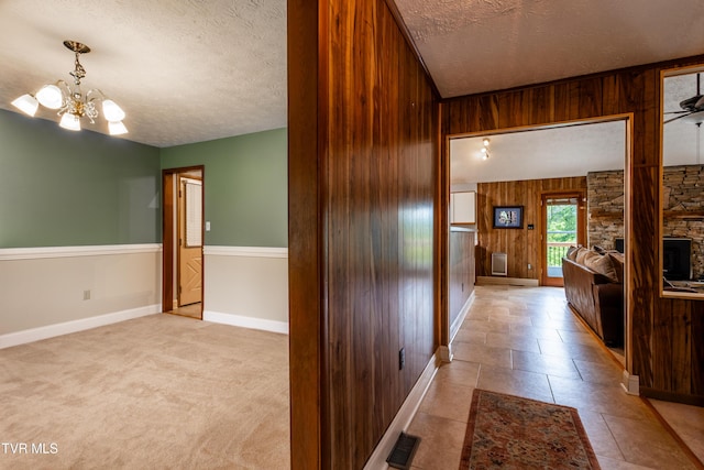 2480 Elk Way, Newport, TN 37821 - corridor featuring a textured ceiling, wood walls, baseboards, and a chandelier