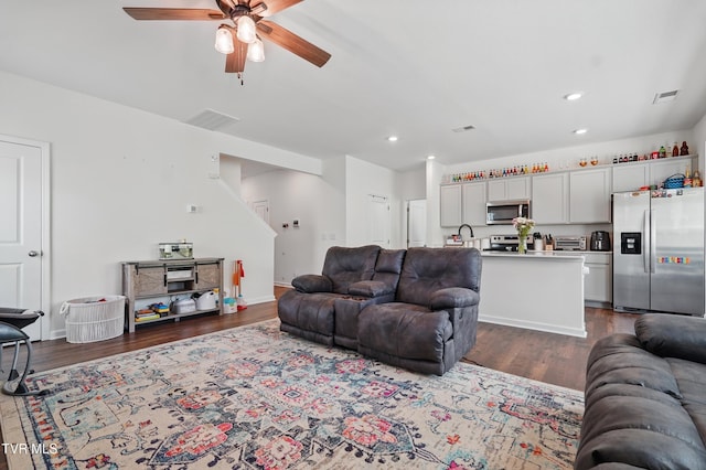 living room featuring a ceiling fan, dark wood-style flooring, and recessed lighting