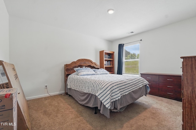 bedroom with light colored carpet and baseboards