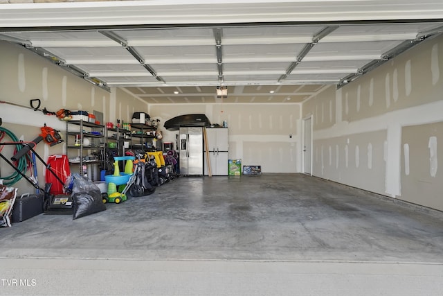 garage with stainless steel fridge and a garage door opener