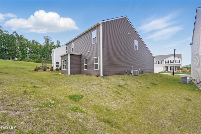 back of property featuring cooling unit and a yard