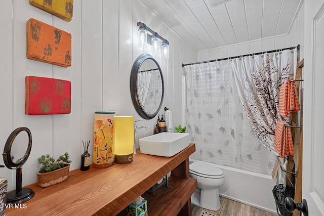 bathroom featuring wood finished floors, toilet, shower / tub combo, and vanity