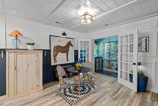 dining space featuring french doors, wood finished floors, wooden ceiling, and wood walls