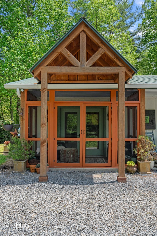 entrance to property featuring metal roof, board and batten siding, and french doors