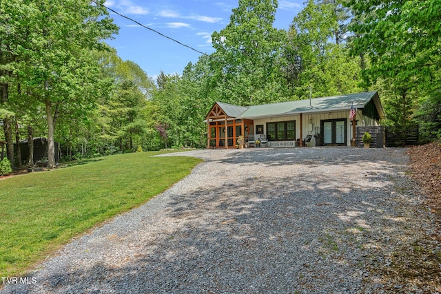 view of front of house featuring french doors, driveway, and a front yard