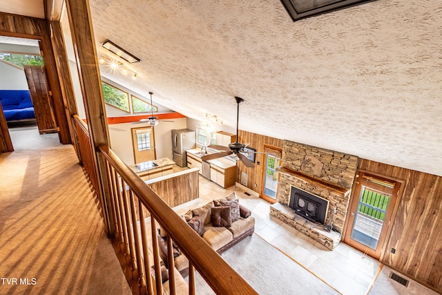 2482-2480 Elk Way, Newport, TN 37821 - living area featuring ceiling fan, a textured ceiling, wood walls, a fireplace, and lofted ceiling