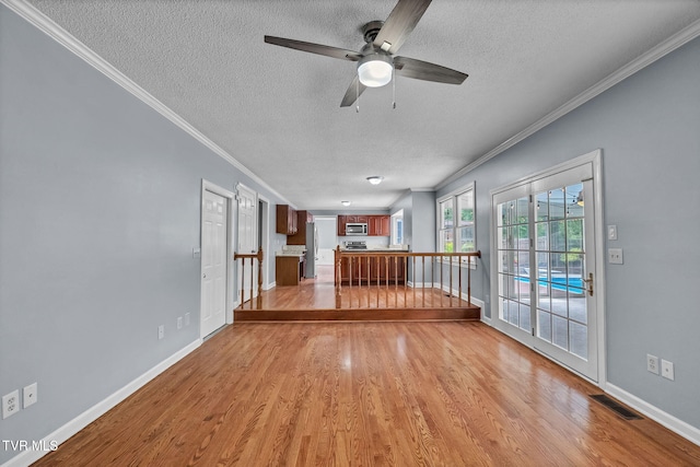20111 Galen Dr, Abingdon, VA 24211 - unfurnished living room featuring a textured ceiling, crown molding, a ceiling fan, light wood-style flooring, and baseboards