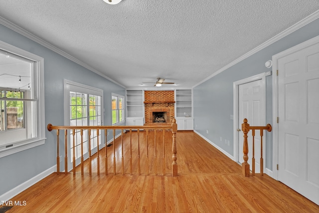 20111 Galen Dr, Abingdon, VA 24211 - unfurnished living room with a textured ceiling, wood finished floors, a ceiling fan, built in features, and a brick fireplace