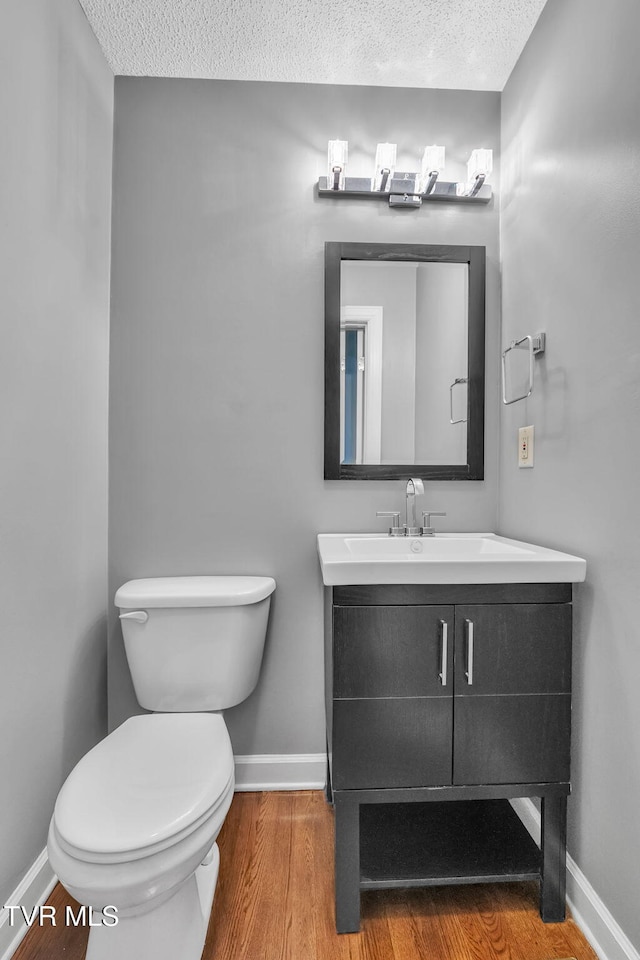 20111 Galen Dr, Abingdon, VA 24211 - bathroom with a textured ceiling, baseboards, wood finished floors, toilet, and vanity
