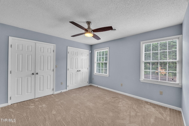 20111 Galen Dr, Abingdon, VA 24211 - unfurnished bedroom featuring two closets, carpet floors, baseboards, a textured ceiling, and ceiling fan