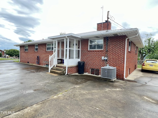 457 Devault St, Church Hill, TN 37642 - rear view of house with driveway, a chimney, central AC unit, and brick siding