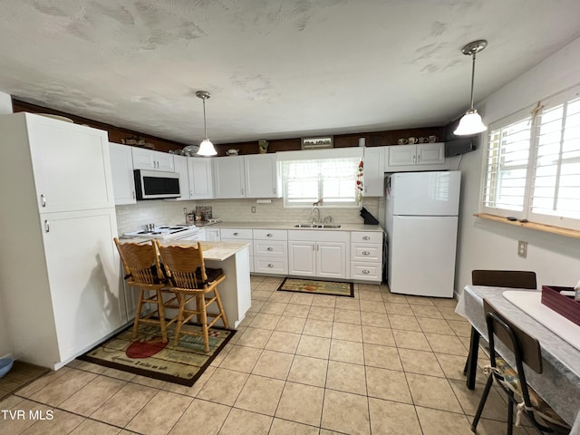 457 Devault St, Church Hill, TN 37642 - kitchen with freestanding refrigerator, stainless steel microwave, light countertops, tasteful backsplash, and white cabinetry