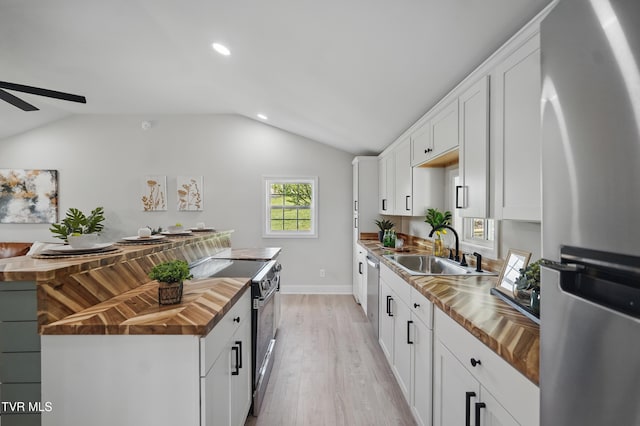 1225 Bristol View Dr, Bristol, VA 24201 - kitchen featuring butcher block countertops, appliances with stainless steel finishes, a sink, vaulted ceiling, and light wood-type flooring
