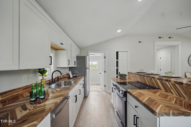 1225 Bristol View Dr, Bristol, VA 24201 - kitchen featuring wood counters, a sink, appliances with stainless steel finishes, vaulted ceiling, and white cabinetry