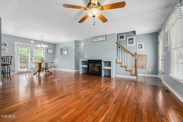 522 Crook St, Hampton, TN 37658 - living room with wood-type flooring, stairs, a glass covered fireplace, a chandelier, and ceiling fan