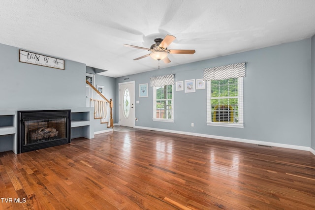 522 Crook St, Hampton, TN 37658 - unfurnished living room featuring wood finished floors, a ceiling fan, baseboards, a textured ceiling, and a fireplace