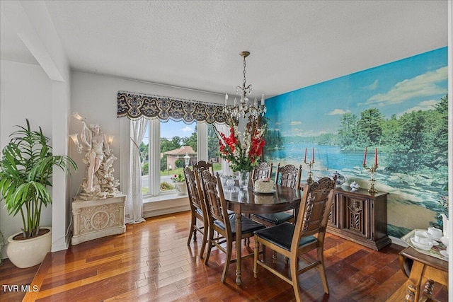 dining space with wood-type flooring, a chandelier, and a textured ceiling