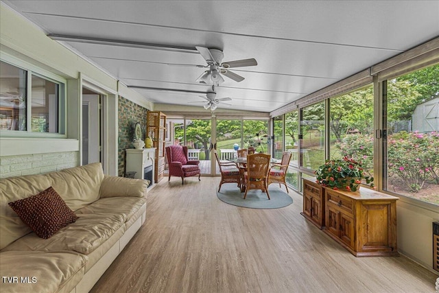 sunroom / solarium featuring an outdoor hangout area, wood finished floors, a ceiling fan, and healthy amount of natural light
