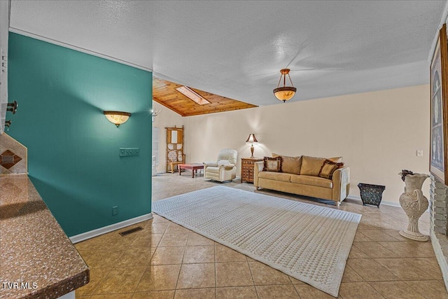 living area with lofted ceiling, tile patterned flooring, baseboards, and a textured ceiling