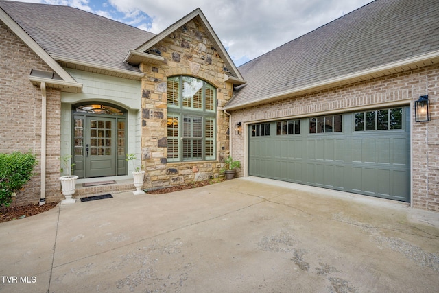 1001 Willows Trace Dr, Johnson City, TN 37601 - property entrance with a shingled roof, concrete driveway, a garage, stone siding, and brick siding