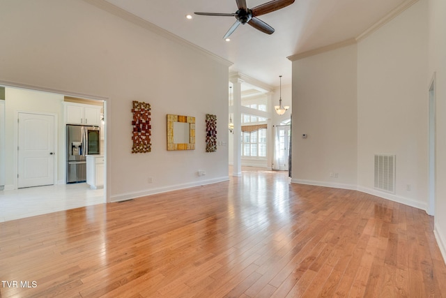 1001 Willows Trace Dr, Johnson City, TN 37601 - unfurnished living room featuring ceiling fan, crown molding, light wood-style floors, a towering ceiling, and baseboards