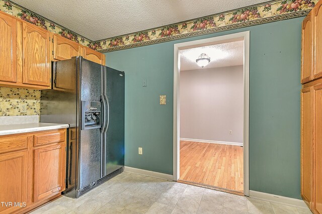 145 Linda Hts, Fall Branch, TN 37656 - kitchen featuring black fridge, a textured ceiling, baseboards, and light countertops