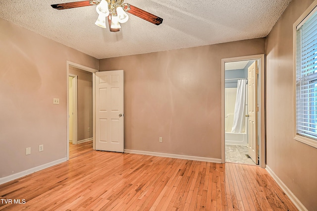 145 Linda Hts, Fall Branch, TN 37656 - unfurnished bedroom featuring a textured ceiling, light wood-style floors, baseboards, ensuite bath, and a ceiling fan