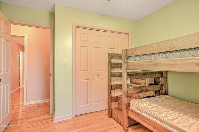 145 Linda Hts, Fall Branch, TN 37656 - bedroom featuring light wood finished floors, a closet, baseboards, and a textured ceiling