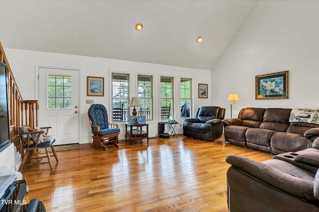 living area featuring high vaulted ceiling, light wood finished floors, stairway, and recessed lighting