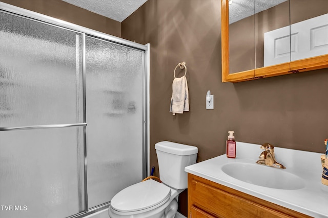 full bath featuring a stall shower, a textured ceiling, toilet, and vanity