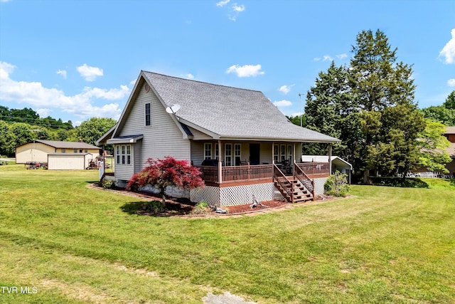 view of front of property featuring covered porch, a front yard, roof with shingles, and a garage