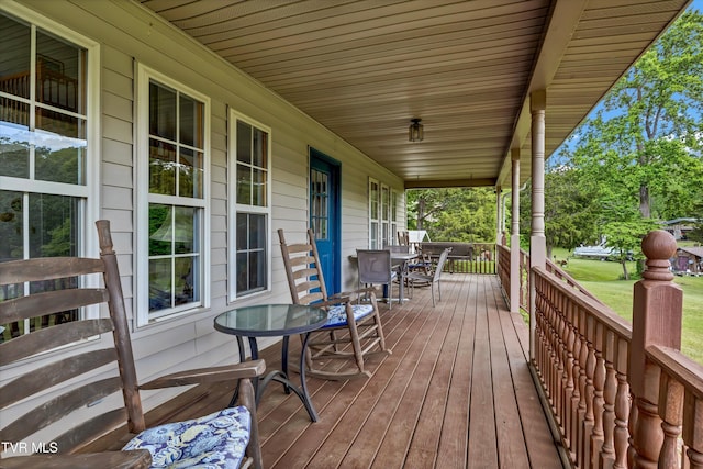 wooden terrace with a porch and outdoor dining area