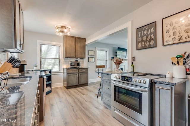 1462 Valley St, Kingsport, TN 37660 - kitchen with electric range, light wood-type flooring, dark stone counters, a sink, and baseboards