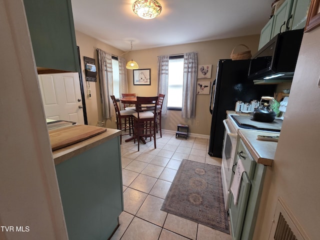 1317 Newton St, Bristol, VA 24201 - kitchen with green cabinets, light tile patterned floors, black microwave, baseboards, and white range with electric cooktop