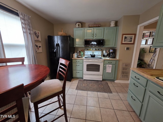 1317 Newton St, Bristol, VA 24201 - kitchen featuring white electric range, green cabinets, black fridge, and stainless steel microwave