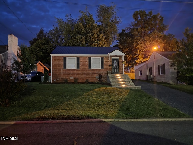 1317 Newton St, Bristol, VA 24201 - view of front of property featuring brick siding, a front lawn, crawl space, central air condition unit, and metal roof